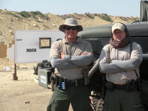 1996 Ford Bronco - Two men in tactical gear pose in front of a vehicle at what appears to be a shooting range.
