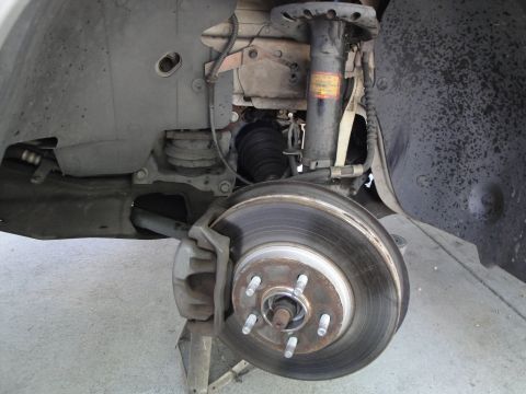 2003 Ford Taurus - The front wheel assembly of a vehicle, showing the brake system and suspension, is pictured here.