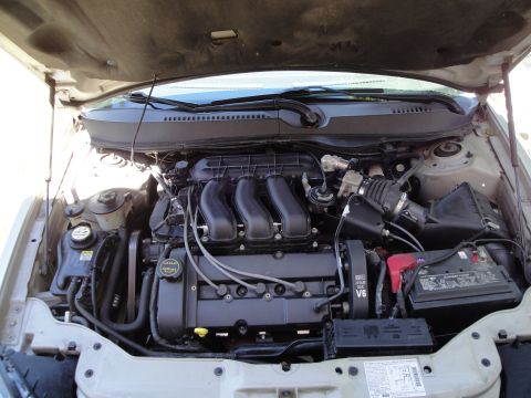 2003 Ford Taurus - The engine bay of a car is shown with the hood open, revealing the V6 engine and associated parts.