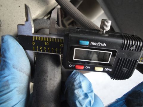 2003 Ford Taurus - A digital caliper is used to measure a dark, cylindrical component, indicating a measurement of approximately 7mm.