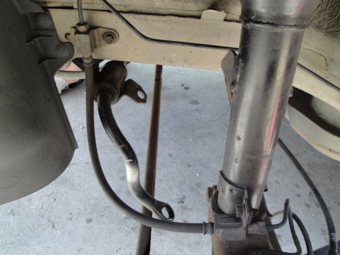 2003 Ford Taurus - A detailed view of the undercarriage suspension system, highlighting the shock absorber and sway bar assembly.