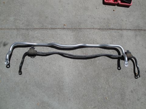 2003 Ford Taurus - Two automotive sway bars are shown side-by-side on a concrete surface.