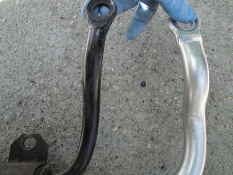 2003 Ford Taurus - A comparison shot shows a worn black suspension component next to its newly cleaned or replaced silver counterpart.