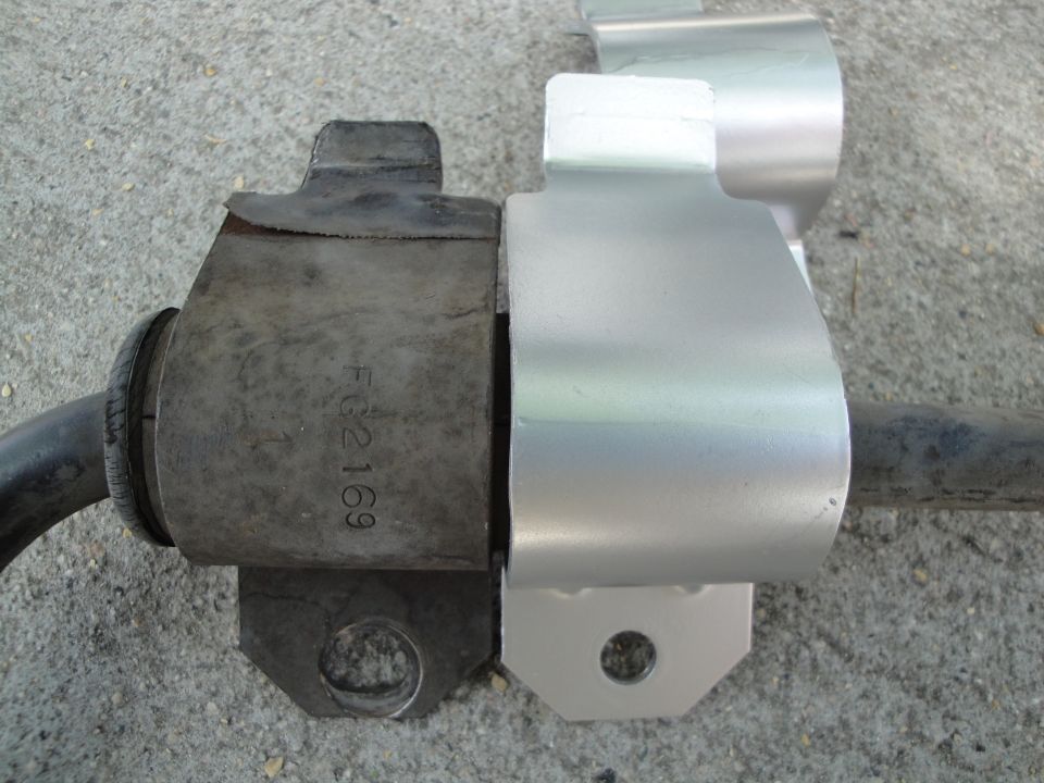 Old rubber sway bar bushing next to a new metal one