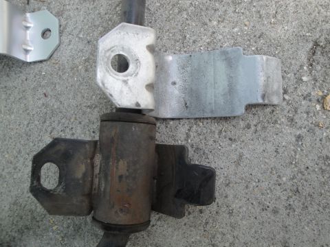 2003 Ford Taurus - A comparison of a new and old car suspension component is shown against a concrete background.