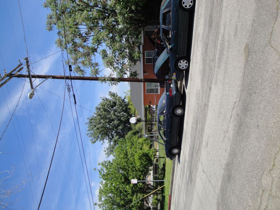 Two dark sedans parked on a street, one behind the other. The front car is a 2003 Ford Taurus