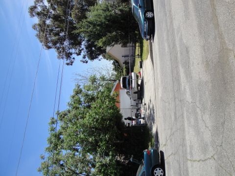 2003 Ford Taurus - A street scene shows multiple vehicles parked along the curb under a clear blue sky.