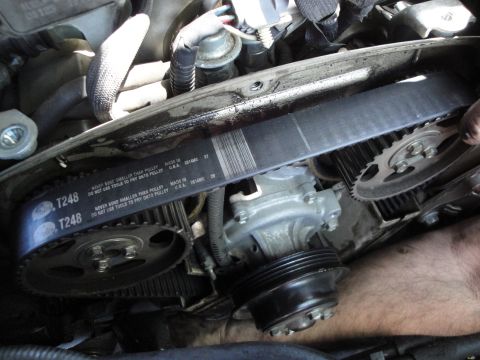 2003 Ford Taurus - Close-up view of a car's engine timing belt and water pump assembly.