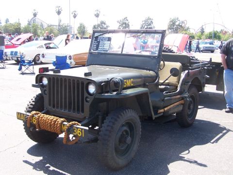 1990 Ford Bronco - This olive drab jeep, marked 'SMC' and with license plates 'MAC 36 M 361', is displayed at an outdoor event.
