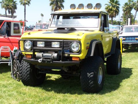 1990 Ford Bronco - This lifted yellow Ford Bronco features a winch and multiple lights on its roof.