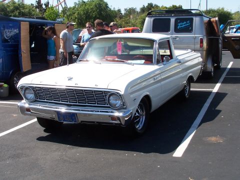 1990 Ford Bronco - A white 1960s pickup truck is parked at an outdoor event with other vehicles and people around.