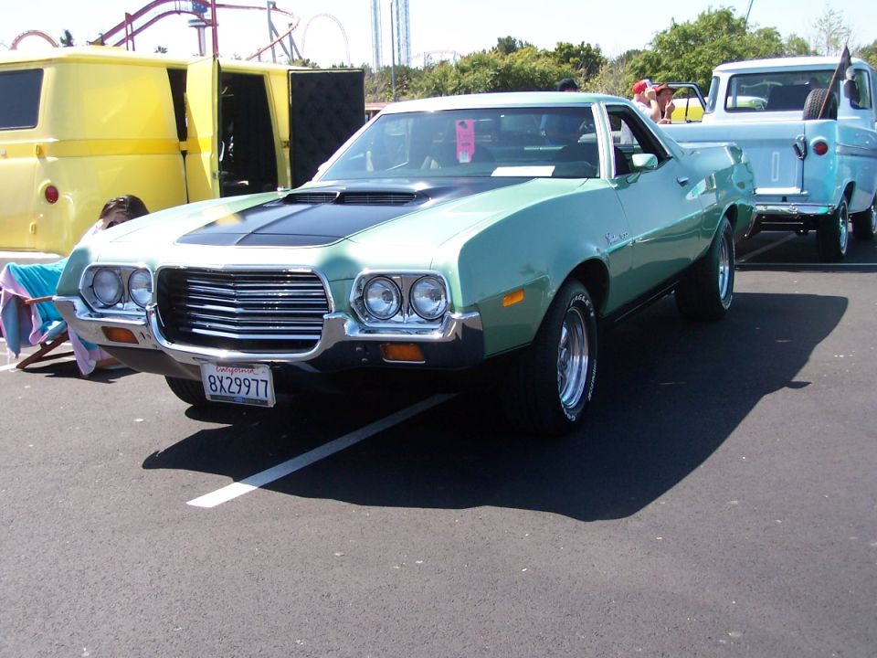 Light green Ford Ranchero with black hood stripe and mag wheels at a car show
