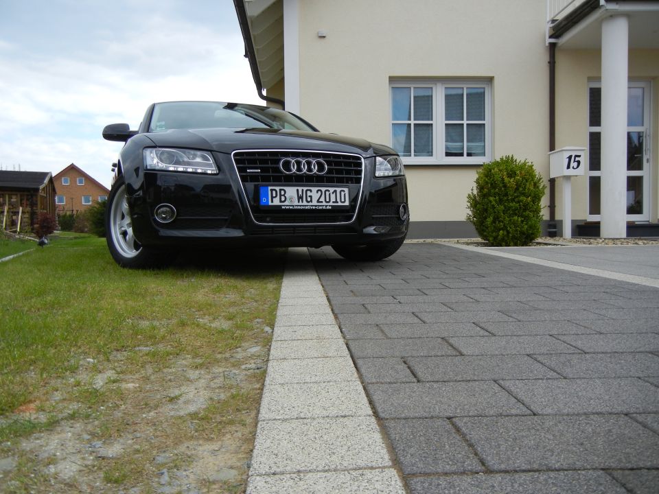 Black Audi with license plate PB WG 2010 parked on a driveway in front of a house
