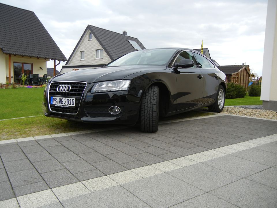Black Audi coupe parked on a paved driveway, front 3/4 view, license plate PB-MG 2010