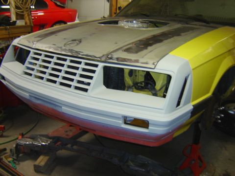 1979 Ford Mustang - Front view of a 1979 Ford Mustang in a repair shop, showing its grille and partially painted body panels.