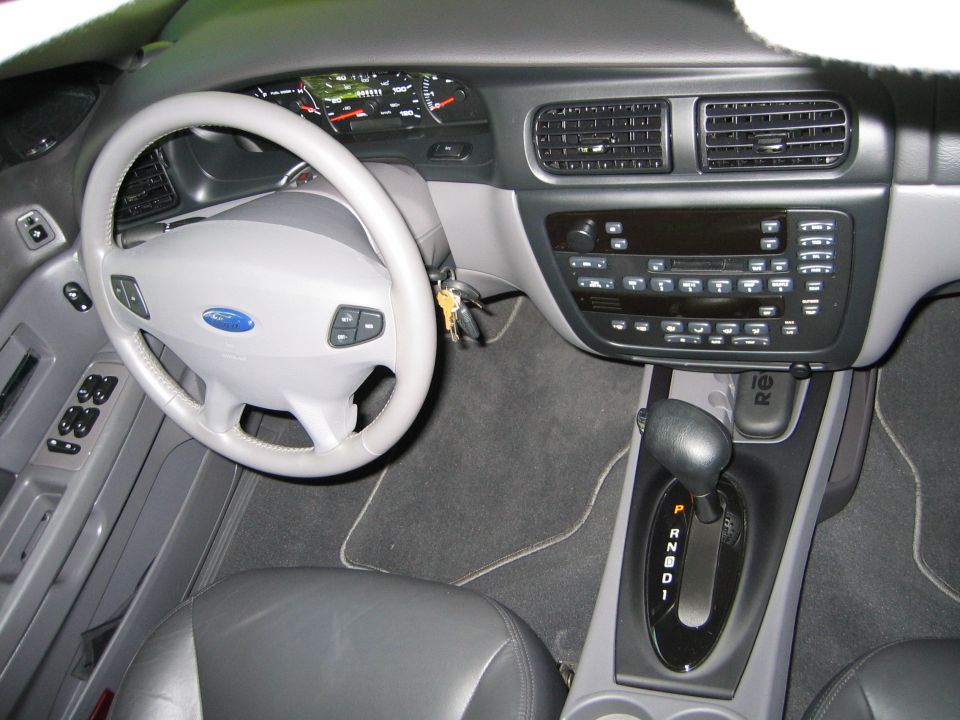 Ford sedan dashboard with airbag steering wheel, automatic shifter and stacked radio/climate controls
