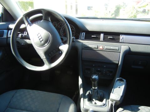 2003 Audi A6 - The interior of the vehicle shows a manual gear shifter and the Audi emblem on the steering wheel.