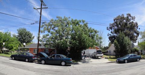 2003 Ford Taurus - Several cars are parked in a residential area on a sunny day, with one car's hood and another's trunk open.