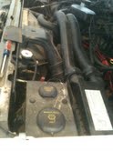 1988 Ford Bronco - Close-up view of a vehicle's engine bay, showing various components and some readable text on caps.