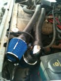 1988 Ford Bronco - Close-up view of an engine bay, highlighting an aftermarket air intake system with a blue filter.