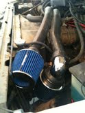 1988 Ford Bronco - Close-up view of an engine's air intake system with dual blue filters.