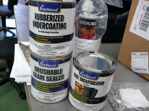 1976 Chevrolet Corvette - Automotive repair products are arranged on a surface, including cans of undercoating and seam sealer.