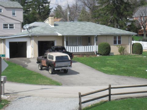 1979 Ford Bronco - A 1978 Ford Bronco and a black Ford F-Series truck are parked in a driveway next to a house.