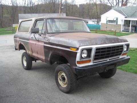 1979 Ford Bronco - This weathered Ford Bronco shows signs of age and previous repairs, with its grille and body style indicating a specific model year.