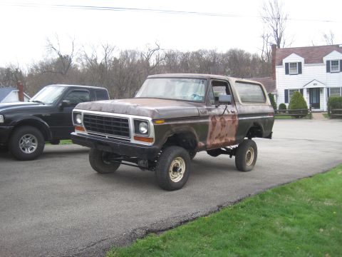 1979 Ford Bronco - A weathered 1978 Ford Bronco sits on a driveway next to a modern pickup truck.