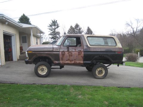 1979 Ford Bronco - This 1979 Ford Bronco displays significant rust and a two-tone paint job, viewed from the side.
