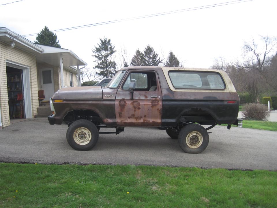 Side view of a rusty 1979 Ford Bronco with a two-tone brown and black paint scheme