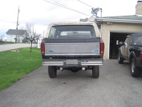 1979 Ford Bronco - Rear view of a 1979 Ford Bronco, parked in a driveway next to another vehicle.
