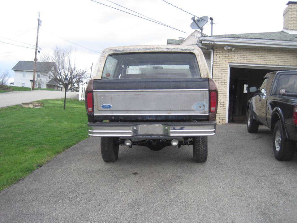 1979 Ford Bronco rear view, parked next to a black pickup truck