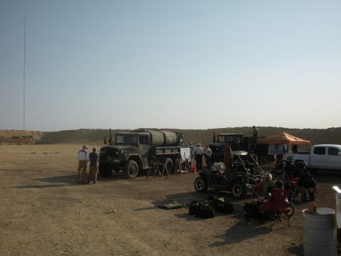 1996 Ford Bronco - A scene with multiple vehicles, including a military truck and a dune buggy, set in an outdoor, arid location.