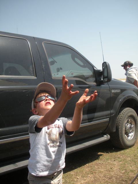 1996 Ford Bronco - A child looks up with hands outstretched in front of a black SUV.