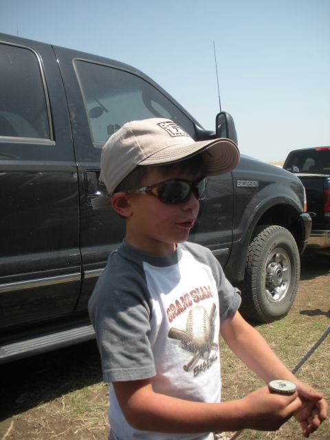 1996 Ford Bronco - A boy stands next to a Ford Excursion SUV, with another truck visible in the background.