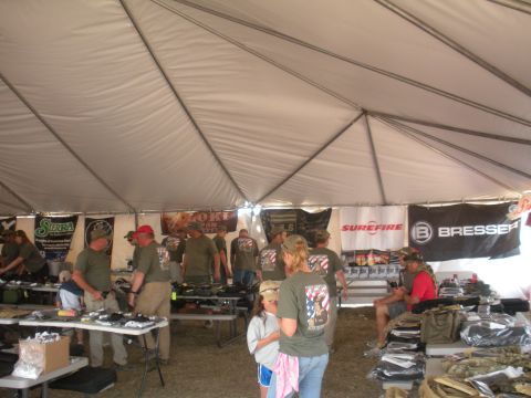 1996 Ford Bronco - A busy outdoor event with vendors displaying goods under a tent, several banners and many attendees.