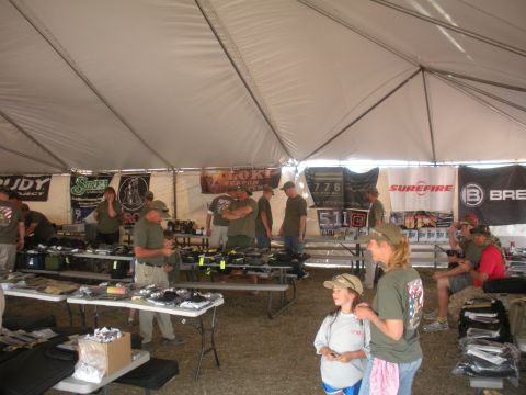 1996 Ford Bronco - An outdoor tent event displays various vendor booths with people browsing merchandise and banners overhead.