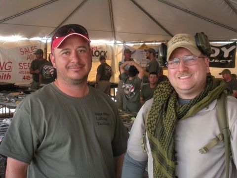 1996 Ford Bronco - Two men pose for a photo at an outdoor event, with other attendees and displays visible in the background.