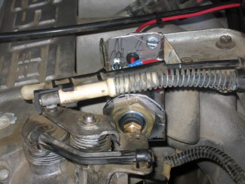 1995 Ford Bronco - This image shows a close-up of a vehicle's throttle linkage and a fitting for an air compressor.