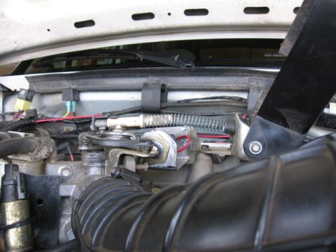 1995 Ford Bronco - Close-up view of engine components, including the throttle body and air intake hose.