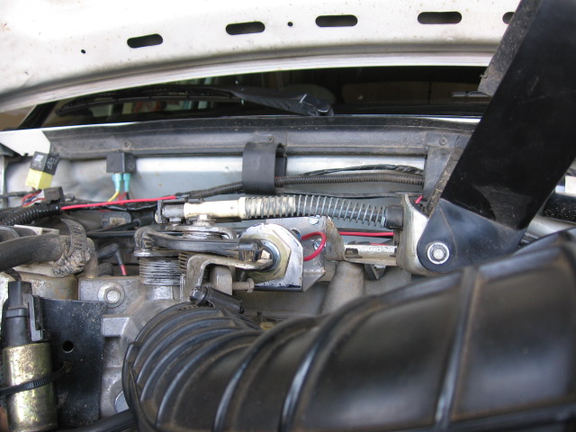 Throttle body linkage with added fast-idle actuator rod and return spring under the hood