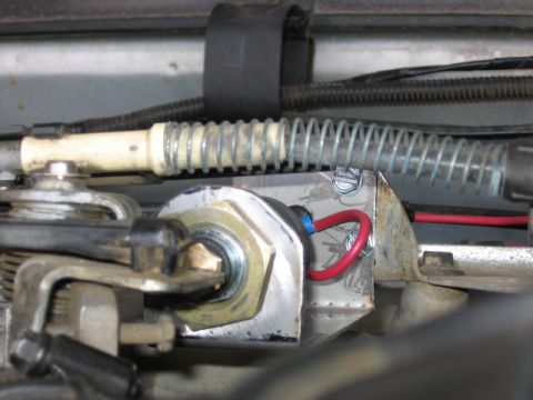 1995 Ford Bronco - Custom-mounted switch with red wire and spring mechanism visible in an engine bay.