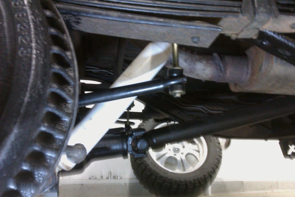 Close-up of rear suspension with leaf springs, shock absorber, and brake rotor