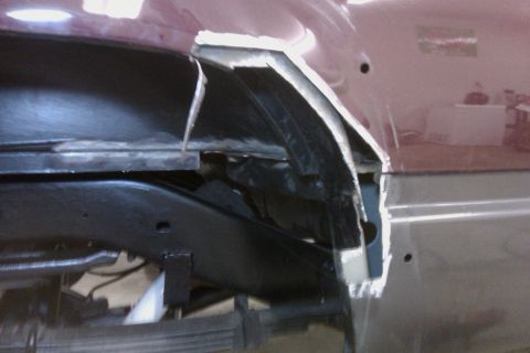 1994 Chevrolet Blazer - Close-up of rust damage and repair in the wheel well of a maroon vehicle.