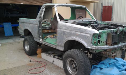 1995 Ford Bronco - This 1995 Ford Bronco is undergoing a paint stripping process, revealing its bare metal body and green interior.