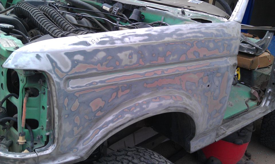 1995 Ford Bronco fender with primer and body filler, showing engine bay details
