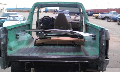 1995 Ford Bronco - This 1995 Ford Bronco is being worked on, with its interior and bed exposed and parts loaded inside.