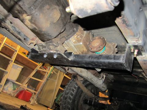 1984 Ford Bronco - The underside of a vehicle is shown, focusing on the drivetrain components and suspension.