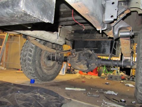 1984 Ford Bronco - Undercarriage view focusing on the rear axle and leaf spring suspension system, with a watermark indicating the source.